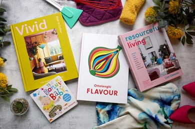 Books spread out on a grey surface surrounded by objects.